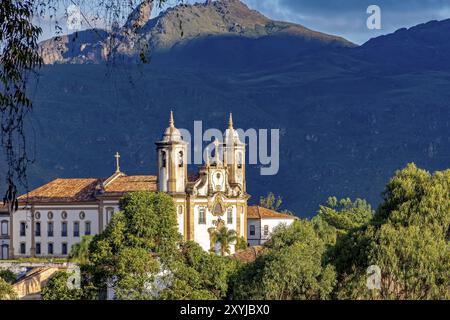 Alte katholische Kirche aus dem 18. Jahrhundert im Zentrum des berühmten und historischen Stadt Ouro Preto in Minas Gerais mit Itacolomy Hügel an der b Stockfoto