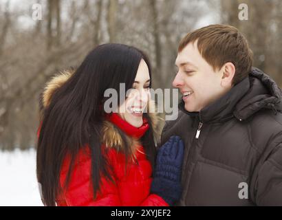 Glückliche junge Paare, die Spaß im Winter park Stockfoto