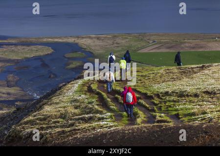 AUSTURLAND, ISLAND, 20. JUNI: Eine Gruppe von Menschen wandert am Rande eines Canyons in der Nähe des Wasserfalls Hengifoss am 20. Juni 2013 in Austurland, Island, Stockfoto