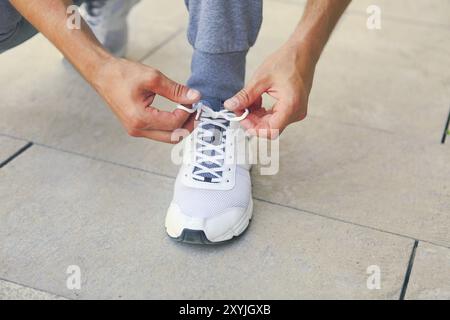 Mann schnürung Schuhe vor dem Training. Close Up. Fitness und gesunde Lebensweise Konzept Stockfoto