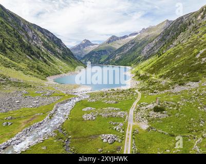 Ein idyllischer Bergsee umgeben von hohen Gipfeln und grünen Wiesen unter blauem Himmel, Klein Tibet, Zillertal, Österreich, Europa Stockfoto