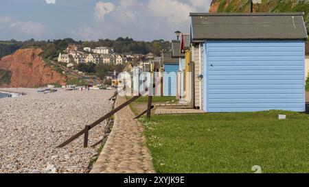 Budleigh Salterton, Jurassic Coast, Devon, England, Vereinigtes Königreich, 19. April 2017: der Kiesstrand mit einigen Strandhütten und das Dorf im Hintergrund Stockfoto