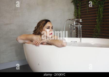 Portrait der glückliche junge Frau, die in der Badewanne entspannen Stockfoto