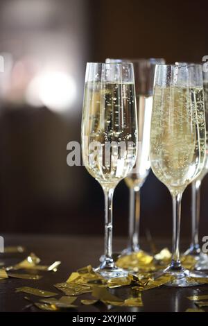 Champagnergläser in goldenem Glanz Hintergrund mit goldenen Konfetti. Nahaufnahme Stockfoto