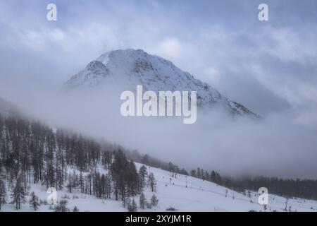 Am frühen Morgen, Blick auf den bewölkten Berggipfel. Montgenevre Skidorf an der Grenze zwischen Frankreich und Italien in den Kottischen Alpen, Frankreich. Wintersport Stockfoto