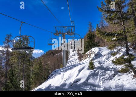 Menschen, die mit einem Skilift hochfahren, um frühe Pisten mit frischem Schnee zu erreichen, das Skidorf Montgenevre an der Grenze zwischen Frankreich und Italien. Wintersport in den Alpen Stockfoto