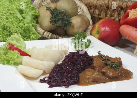 Wildgulasch mit Knödeln und Rotkohl Stockfoto