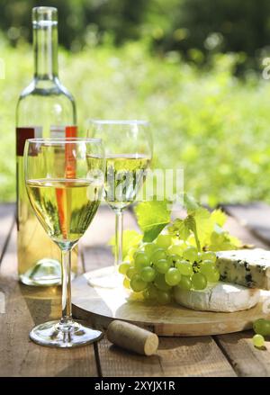 Käse, Weintrauben und zwei Gläser Weißwein im freien Stockfoto