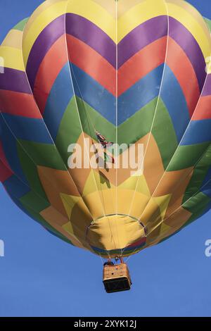 Farbige Heißluftballon im Flug vor blauem Himmel Stockfoto