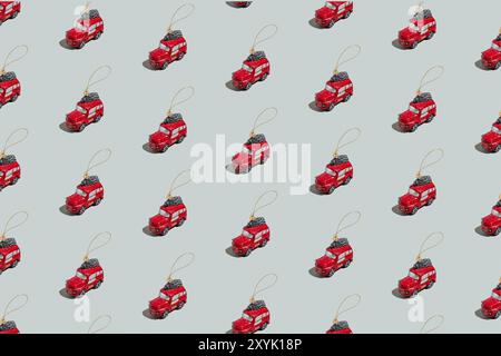 Graugrünes Hintergrundmuster mit Weihnachten oder Neujahr Symbol Attribut Objekte und symbolische Elemente Konzept. Kleines rotes englisches Taxi Auto Spielzeug mit Rippenbund Stockfoto