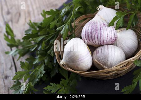 Chinesische solo Knoblauch in einem kleinen Weidenkorb auf hölzernen Hintergrund. Selektiven Fokus Stockfoto