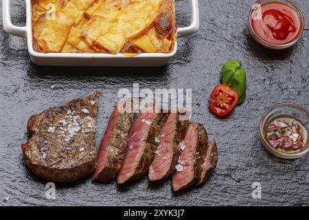 Rindfleisch, Steak, Kartoffeln, Kartoffelgratin, Soße, Pfeffer, weiß, Essen, Fleisch, Abendessen, Gourmet, Restaurant, Gratin, Filet, Mahlzeit, rot, gebraten, Teller, geröstet, V Stockfoto