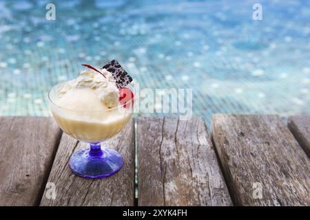 Mango-Eis mit Schokolade und Kirschen am Pool Stockfoto