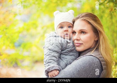 Happy Family im Freien. Mutter und ihre kleine Tochter spielen, kuscheln sich Herbst Spaziergang in der Natur im Freien Stockfoto