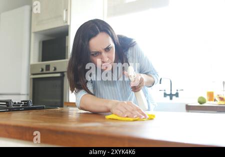 Brünette Frau mit rag und Sprühflasche Reinigung Holz- Zähler - top Stockfoto