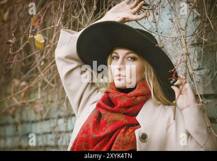 Schöne junge blonde Frau mit langen Haaren im Wind Hut im park Stockfoto