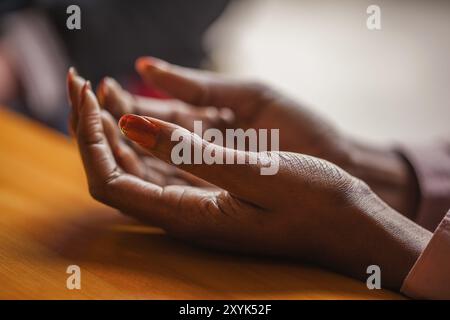 Die Hände einer Frau liegen entspannt auf einem Tisch Stockfoto