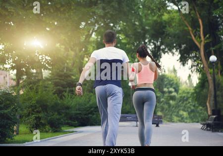 Paar joggen außerhalb, Läufer training draußen im Park arbeiten mit Sonnenuntergang Licht Stockfoto