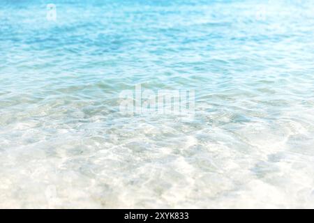 Nahaufnahme des kristallklaren türkisfarbenen Meeres und der weichen blauen Wellen des Ozeans, weißer Schaum am goldenen Sandstrand der tropischen Insel, Urlaub Borde Stockfoto