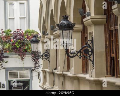 Historische Laternen hängen an der Wand eines Gebäudes mit Bögen und Pflanzen in der Stadt, La palma, den kanarischen Inseln, spanien Stockfoto