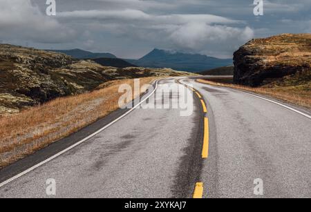Straße führt durch die norwegische strenge Tundra Natur aus nächster Nähe Asphaltblick. Malerische Landschaft im Norden Norwegens und moderner Autobahnbau Stockfoto