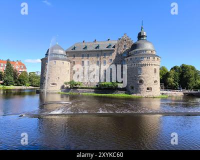 Das Schloss Örebro befindet sich im Herzen von Örebro, Schweden, und ist eine beeindruckende mittelalterliche Festung, die von einem ruhigen Graben umgeben ist. Ursprünglich im 13. jahrhundert erbaut Stockfoto