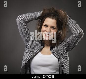 Porträt von die Brünette Schönheit lächelndes Mädchen mit Kopfhörern Stockfoto