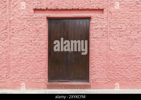 Lima, Peru, 03. September 2015: Foto einer pinkfarbenen Wand mit Holztür, Südamerika Stockfoto