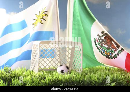 Flagge von Uruguay und Mexiko mit Fußballtor und Fußball auf einer Wiese Stockfoto