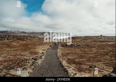 Zwei Wanderer auf einem Küstenweg am Strand Reynisfjara, Island, im Frühjahr Stockfoto