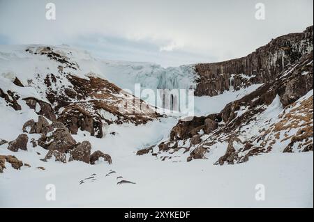 Gefrorener Svöðufoss-Wasserfall mit Schnee und Basaltfelsen in Island Stockfoto