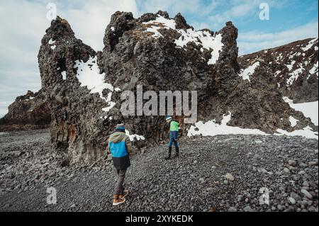 Zwei Brüder erkunden den felsigen schwarzen Strand Djúpalónssandur Island. Stockfoto