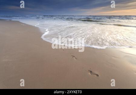 Fußabdrücke am Sandstrand bei Sonnenuntergang, Nordsee, Niederlande Stockfoto