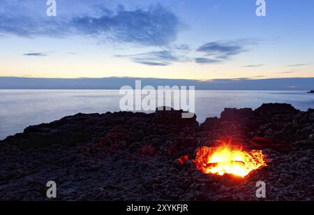 Kleines Lagerfeuer an der felsigen Küste bei Nacht. Schwarzmeer, Krim, Ukraine, Europa Stockfoto