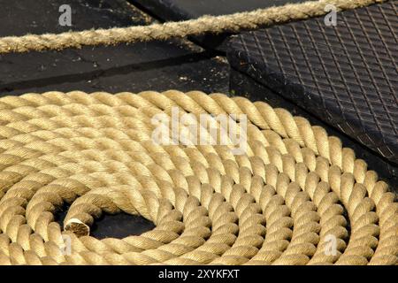 Nahaufnahme eines alten ausgefransten Bootsseils im Kreis, auf dem Deck eines Bootes Stockfoto