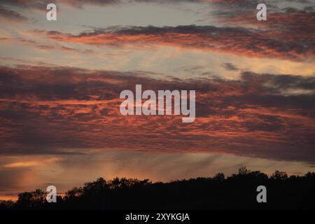 Rote Wolken, die bei Sonnenuntergang von der Sonne beleuchtet werden Stockfoto