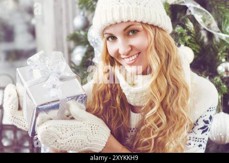 Glückliche junge Frau mit in die Hände von den Weihnachtsbaum Weihnachtsgeschenk Stockfoto