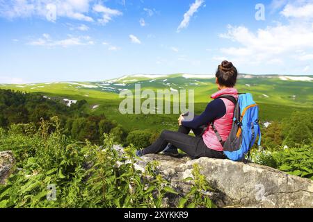 Wanderer mit Rucksack auf einem Berg entspannen und genießen Talblick bei Sonnenaufgang Stockfoto