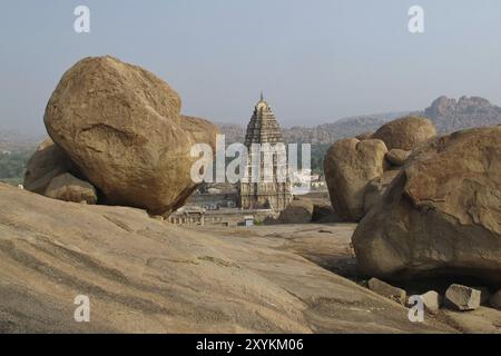 Szene in Hampi, Indien. Virupaksha Tempel und großer Granitfelsen. UNESCO-Weltkulturerbe in Karnataka. Antike Stadt Stockfoto