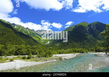 Pristine, kristallklaren Azusa River fließt unter schneebedeckten Berg Hotaka Dake in der Japanischen Alpen Dorf Kamikochi, Nagano, Japan. Horizontale Stockfoto