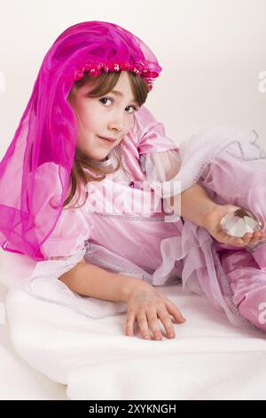 Das kleine Mädchen spielt Prinzessin in einem rosa Kostüm Stockfoto