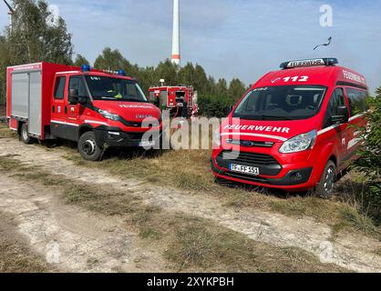 30. August 2024, Brandenburg, Jüterbog: Feuerwehrfahrzeuge in Jüterborg. Der Waldbrand auf dem ehemaligen Militärübungsplatz bei Jüterbog in Brandenburg hat sich ausgebreitet. Derzeit sind etwa 50 Hektar betroffen, so ein Sprecher der Feuerwehr. (Zu dpa „Waldbrand bei Jüterbog breitet sich aus“) Foto: Sven Kaeuler/TNN/dpa Stockfoto