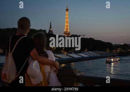 Ein Paar beobachtet den Eiffelturm von einer Brücke aus während der Olympischen Spiele 2024, am Freitag, den 2. August 2024, in Paris. Frankreich. Stockfoto