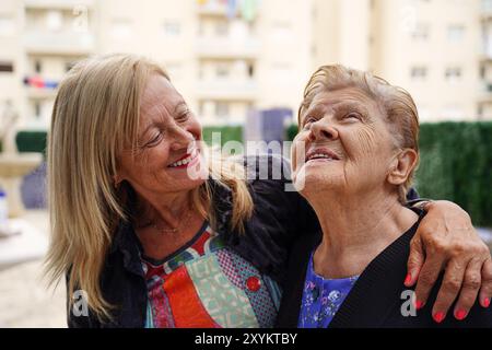 Mutter und Tochter lachen und haben Spaß auf der Terrasse. Glückliche Familie Stockfoto