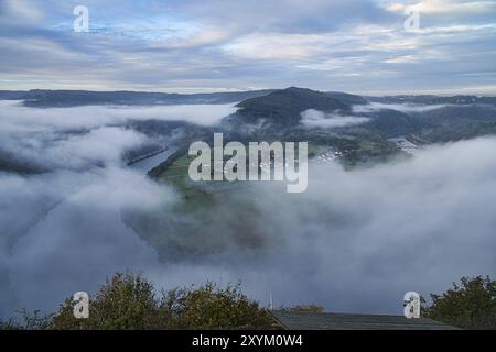 Nebel steigt auf den Bergen der kleinen Saarschleife. Mystische Stille an der Saar im Saarland Stockfoto