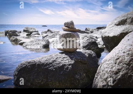 Steinpyramide an der Ostseeküste mit Blick auf das Meer in der Sonne. Spirituelle Sichtweise. Landschaftsaufnahmen von Poel Island Stockfoto