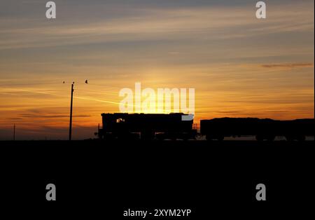 Trainiere die Silhouette über dem farbenfrohen orangefarbenen Sonnenuntergang Stockfoto