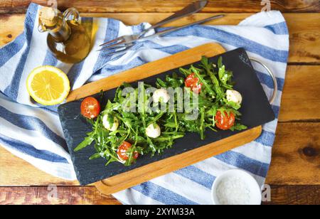 Frischer Frühlingssalat mit Rucola, Fetakäse, Tomaten mit Olivenöl Stockfoto