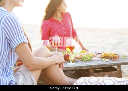 Junge Freunde trinken Rosé auf Sommer-Strand-Picknick. Sommer-Urlaub und Party-Konzept Stockfoto