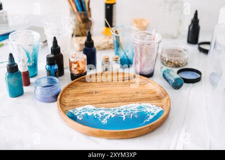 Erstellen Sie atemberaubende Epoxidharzkunst mit leuchtenden Farben und Texturen für ein Serviertablett mit Küstenmotiven in einer DIY-Werkstatt Stockfoto